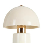 Ceramic cream table lamp by SKAY with a sleek design, illuminating a cozy living space.