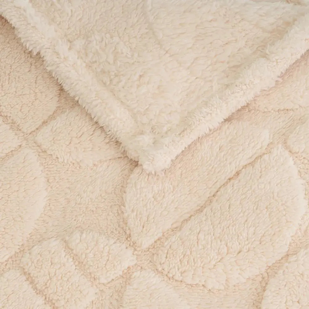 Cozy SKAY MANTA JACQUARD blanket featuring a textured design in soft, warm colors, perfect for home decor.